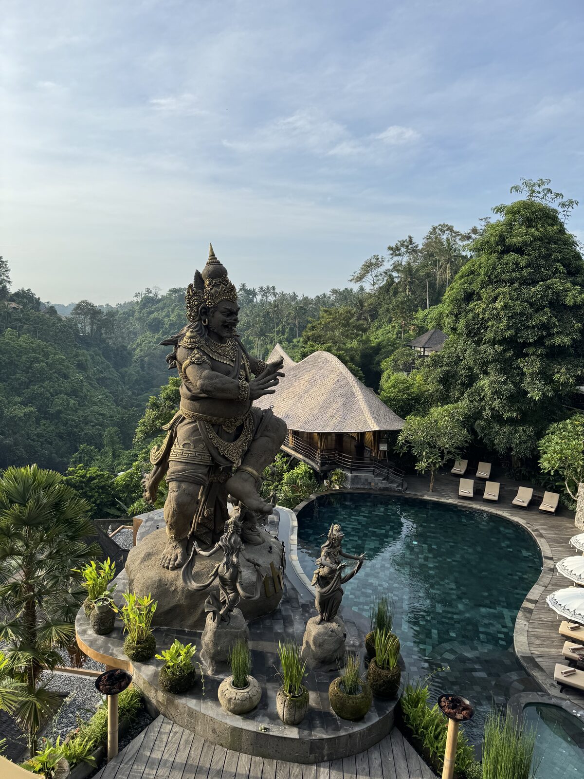 Giant Balinese guardian statue beside resort pool